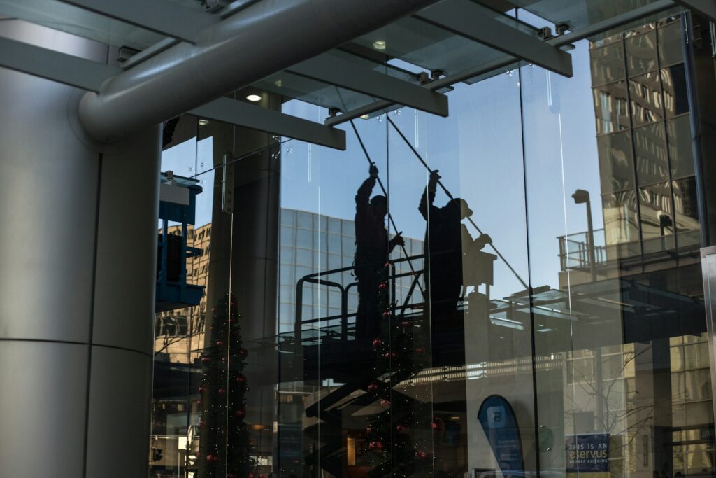 Professional window cleaner working on a large glass facade